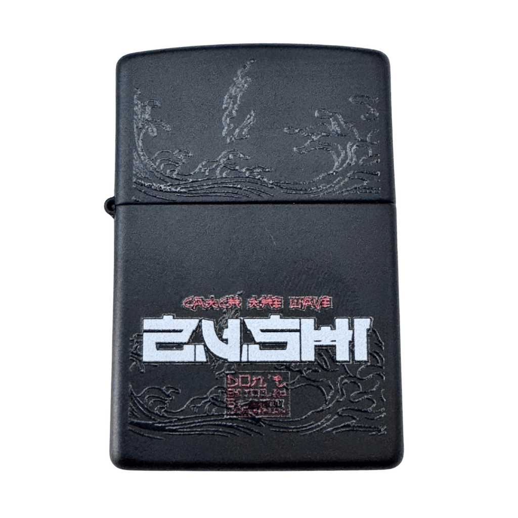Black Zushi x Zippo lighter close up showing matte black case with engraved wave design and white Zushi logo on front